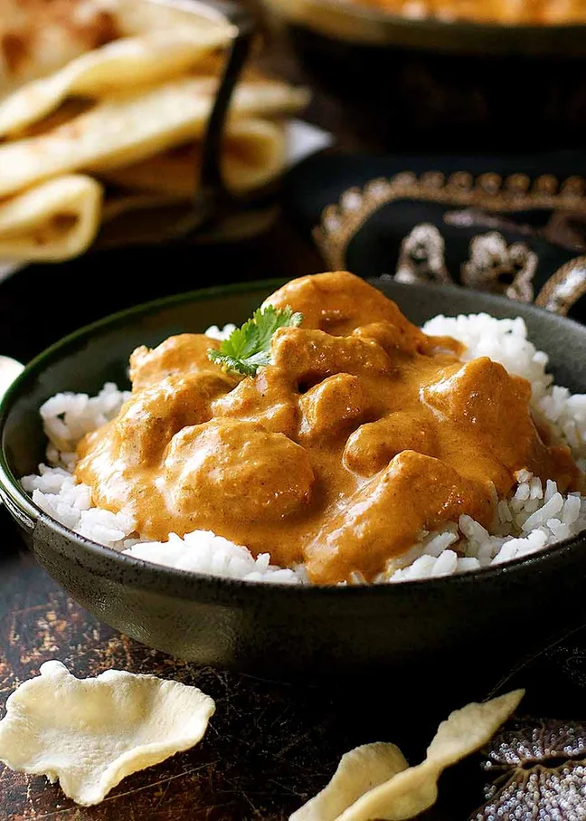 Butter chicken in a creamy orange sauce served with naan bread