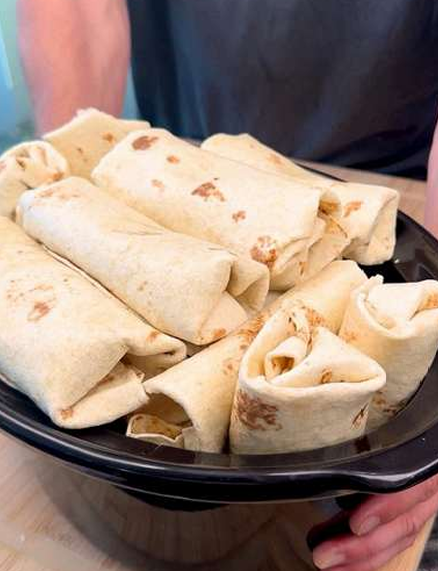Cheesy chicken and rice burritos stacked on a plate