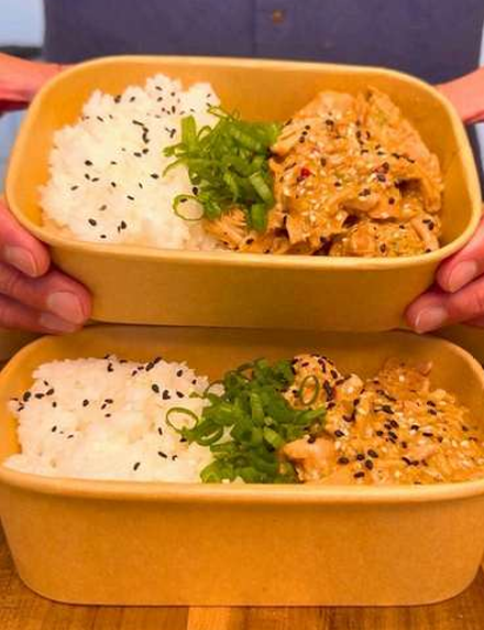 Peanut miso chicken rice bowls garnished with green onions and sesame seeds